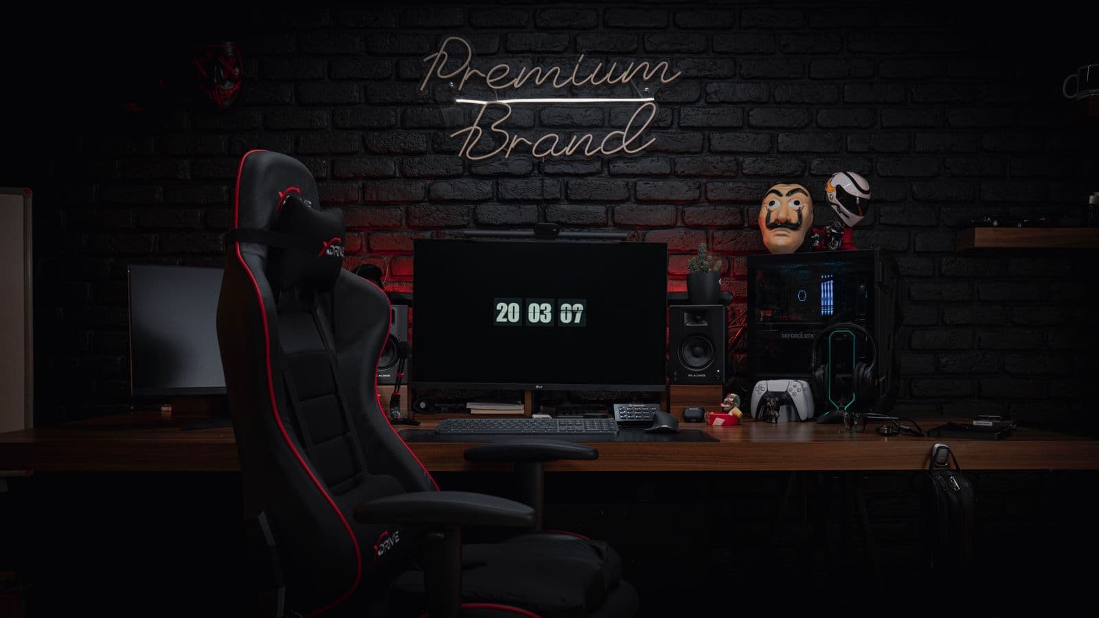 A black and red racing-style gaming chair with a strap-on neck pillow pulled up to a wooden desk with a monitor and keyboard
