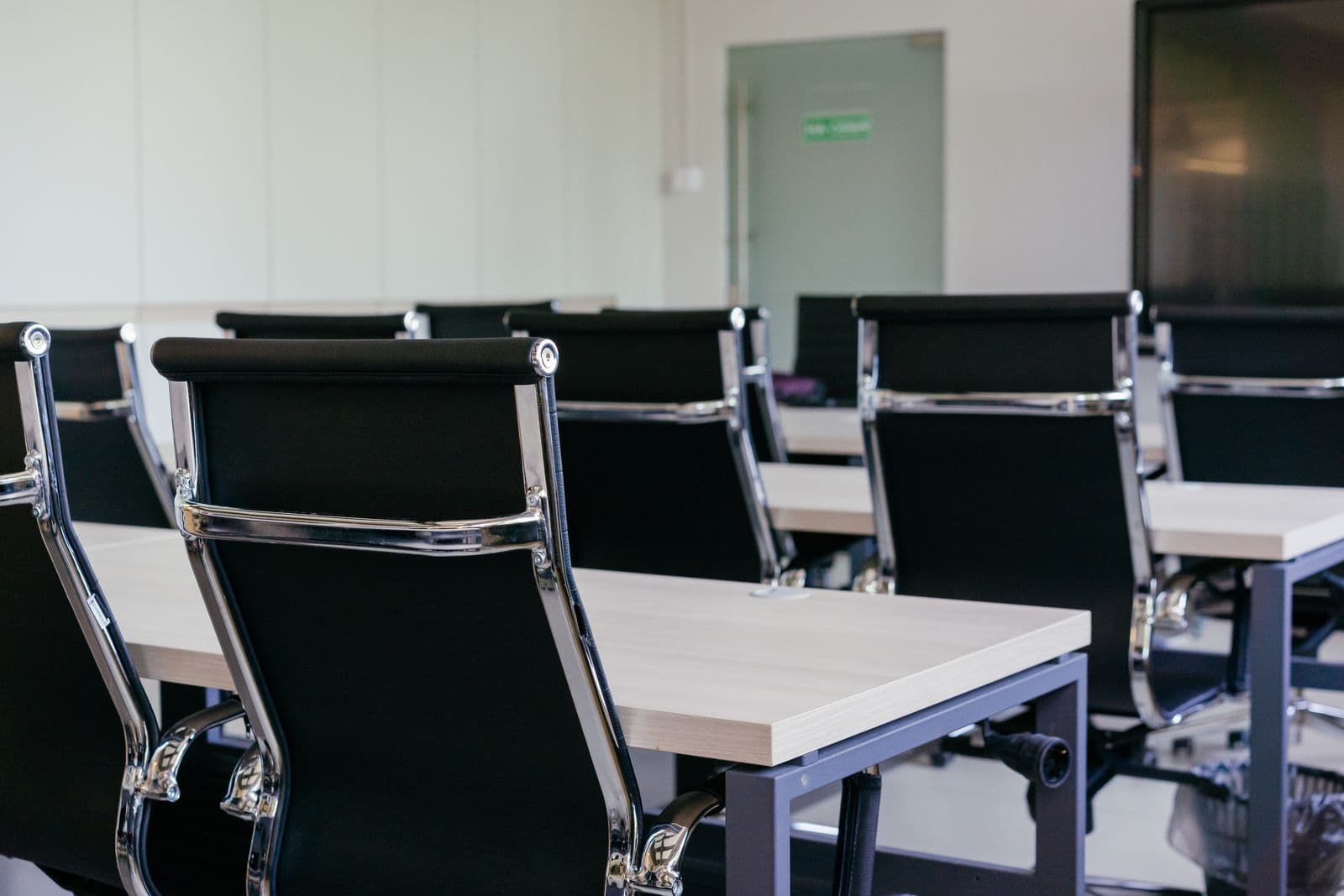 A row of mesh-backed office chairs at a shared work table