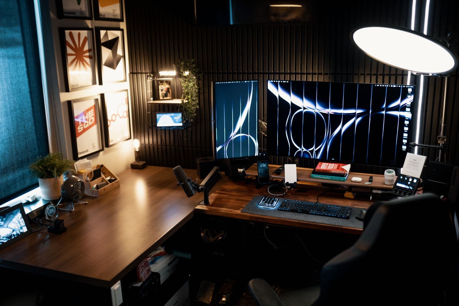 A home office built around an L-shaped wooden desk with two monitors in the corner