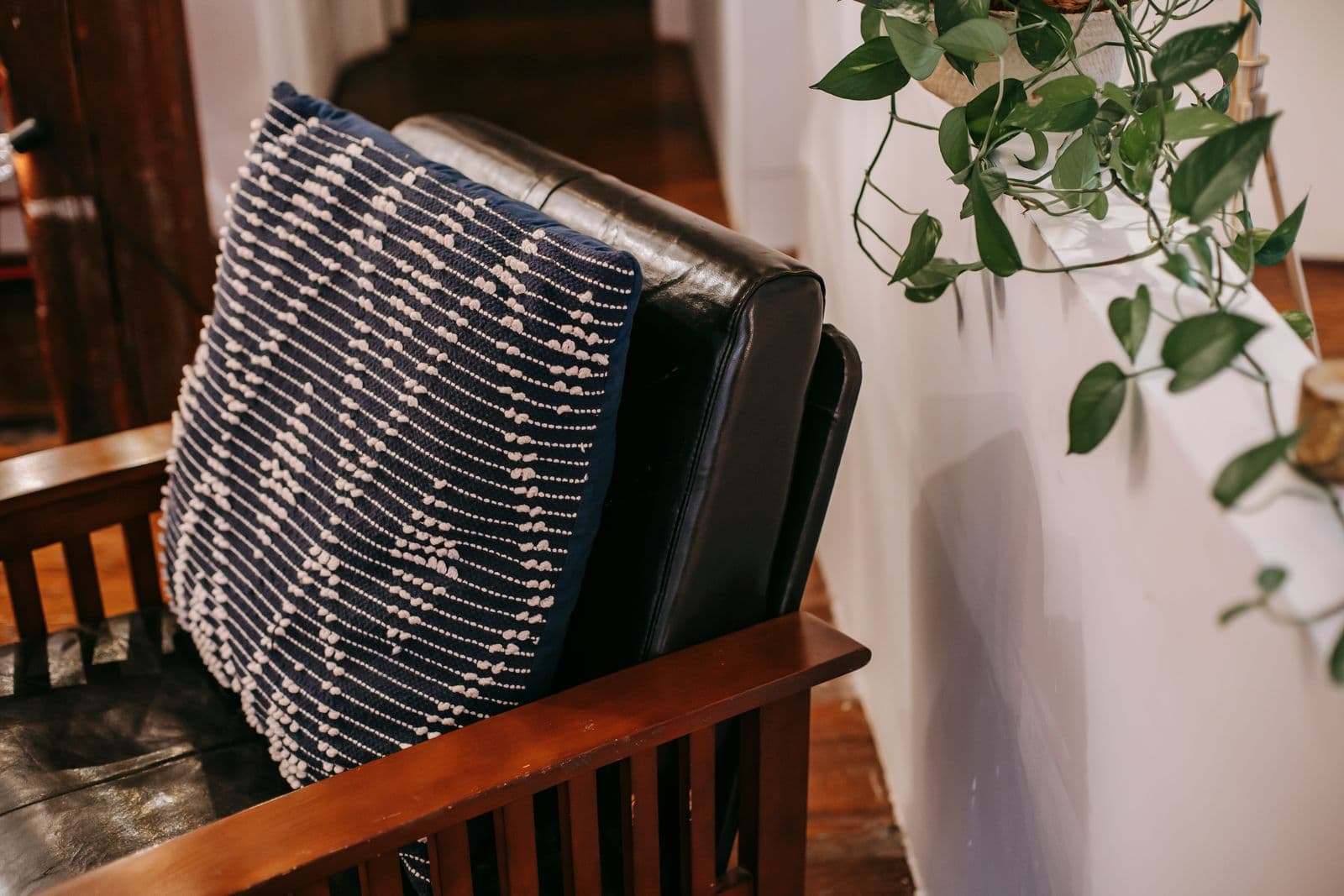 A cushion resting on a wooden chair in a bright room