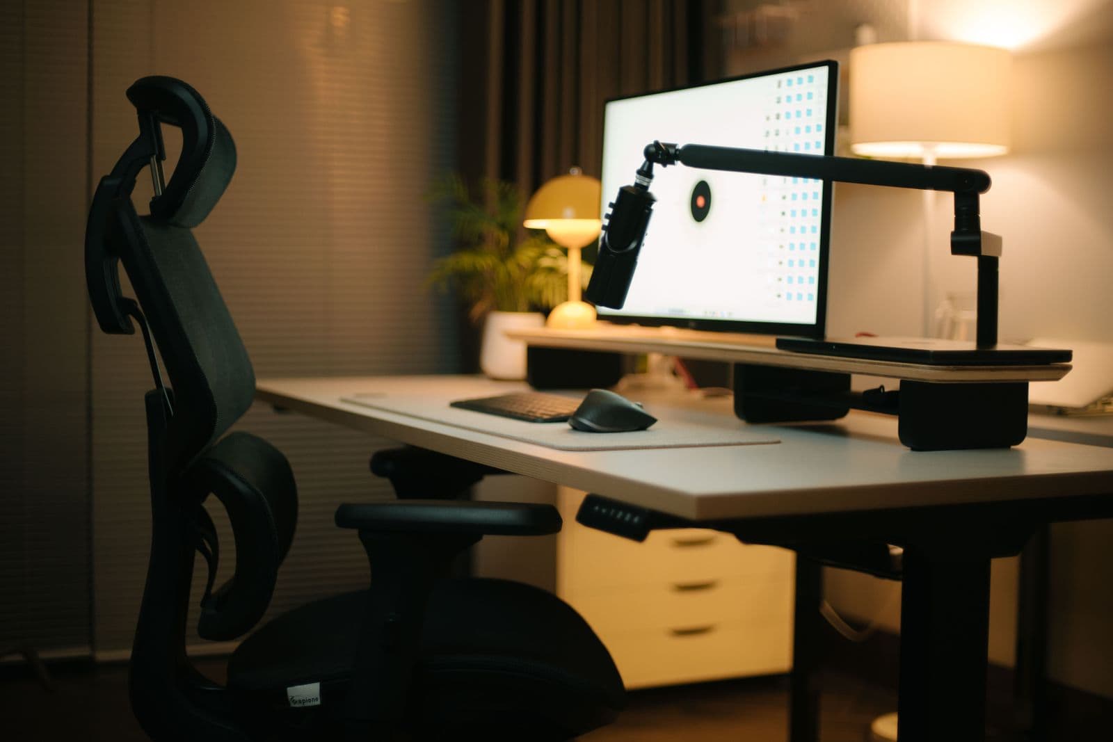 A home office with an ergonomic chair positioned at a wooden desk