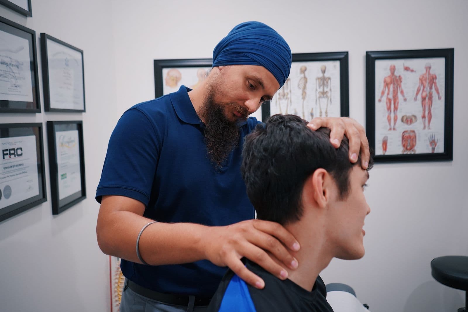 A practitioner assessing a seated person's neck position