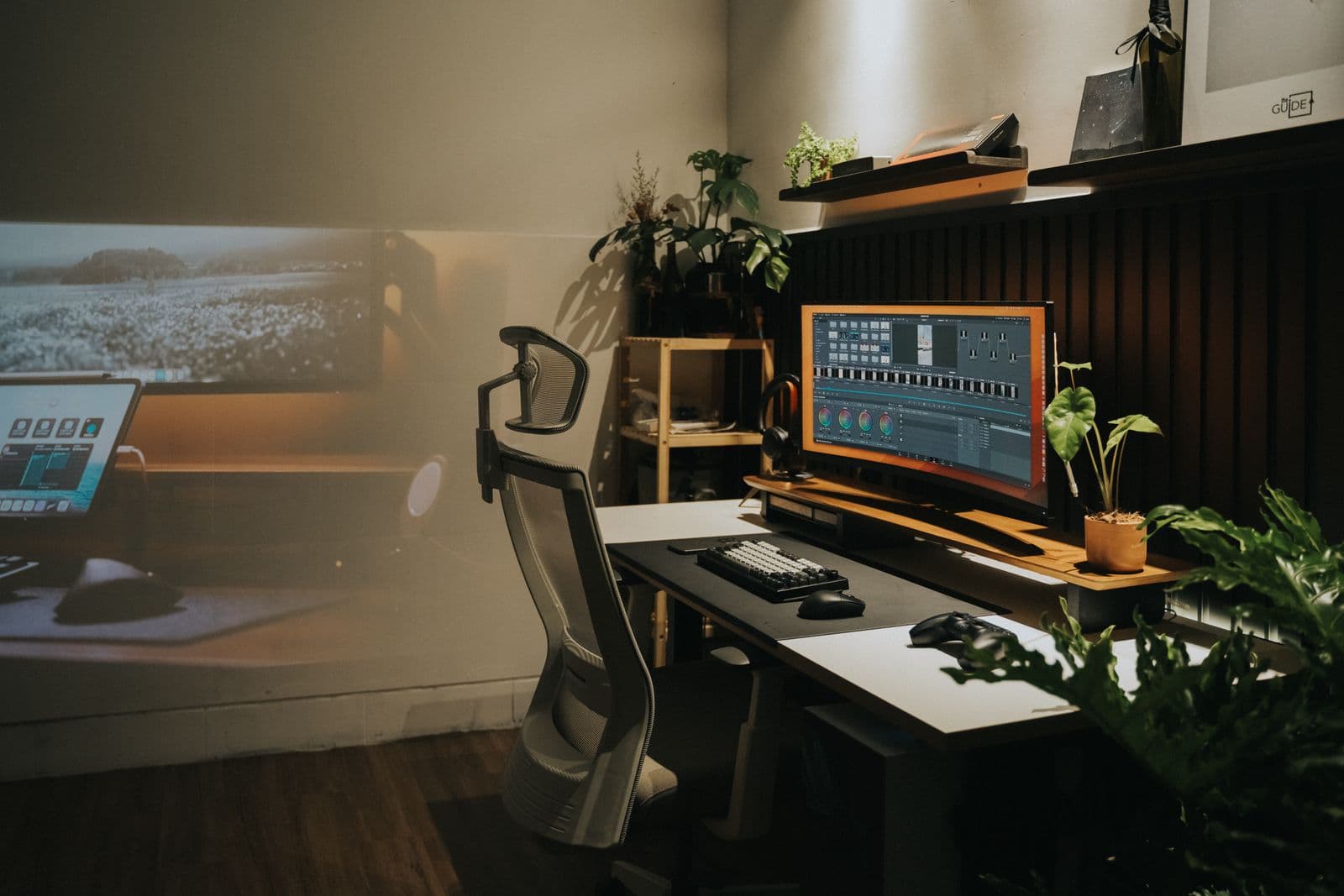A home office with a mesh task chair and a curved monitor