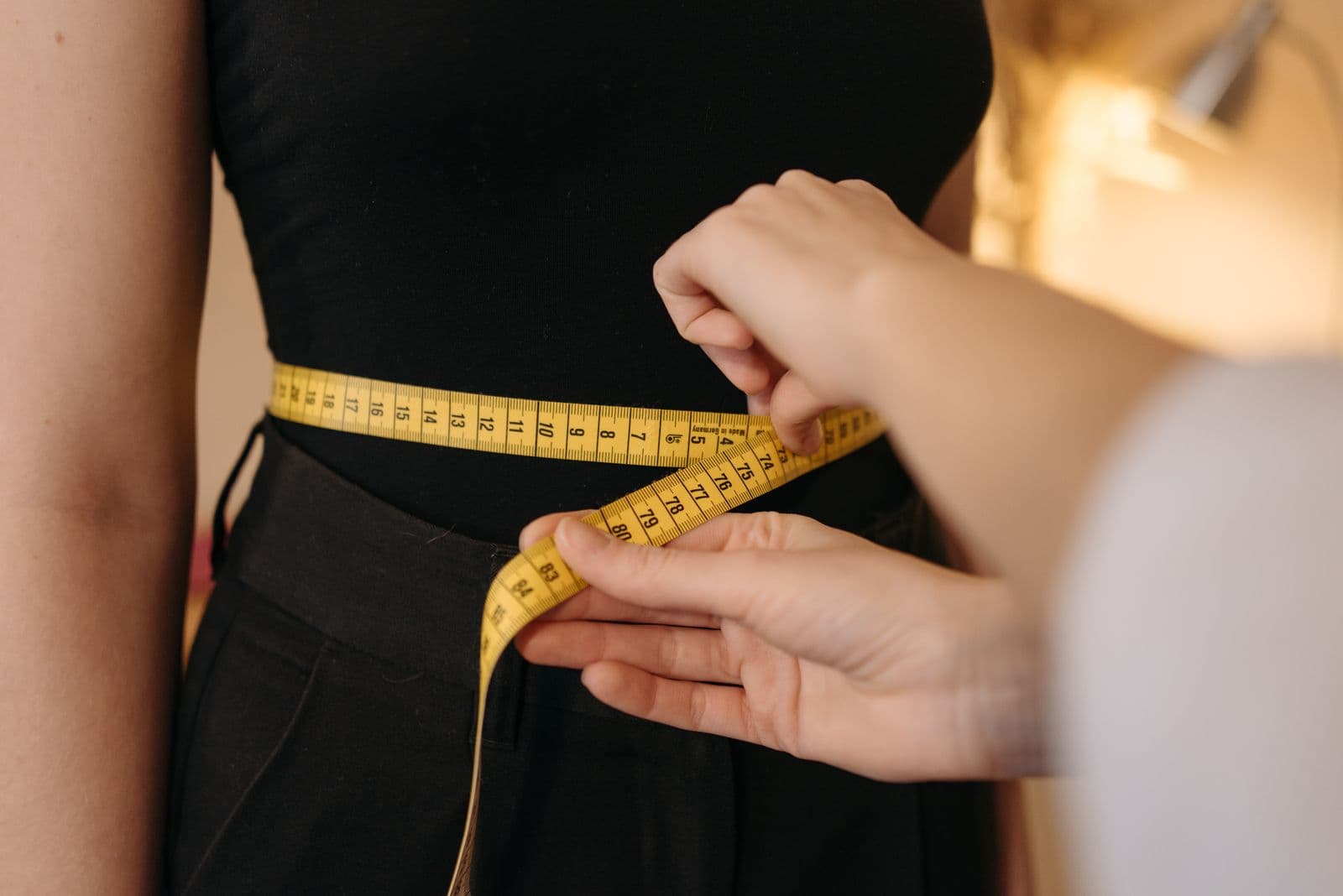 A tape measure being drawn around a person's torso