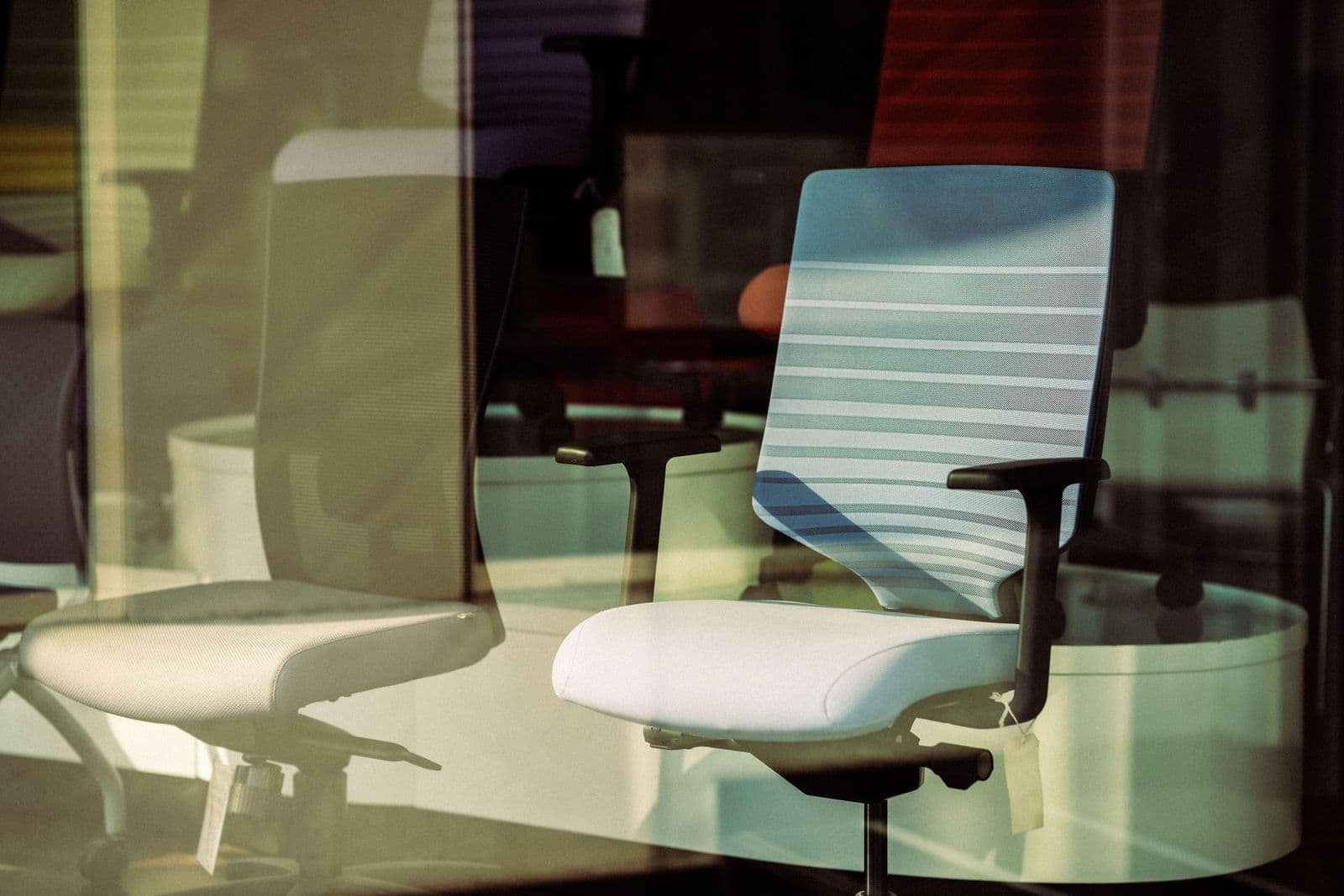 A row of office chairs seen through a showroom window