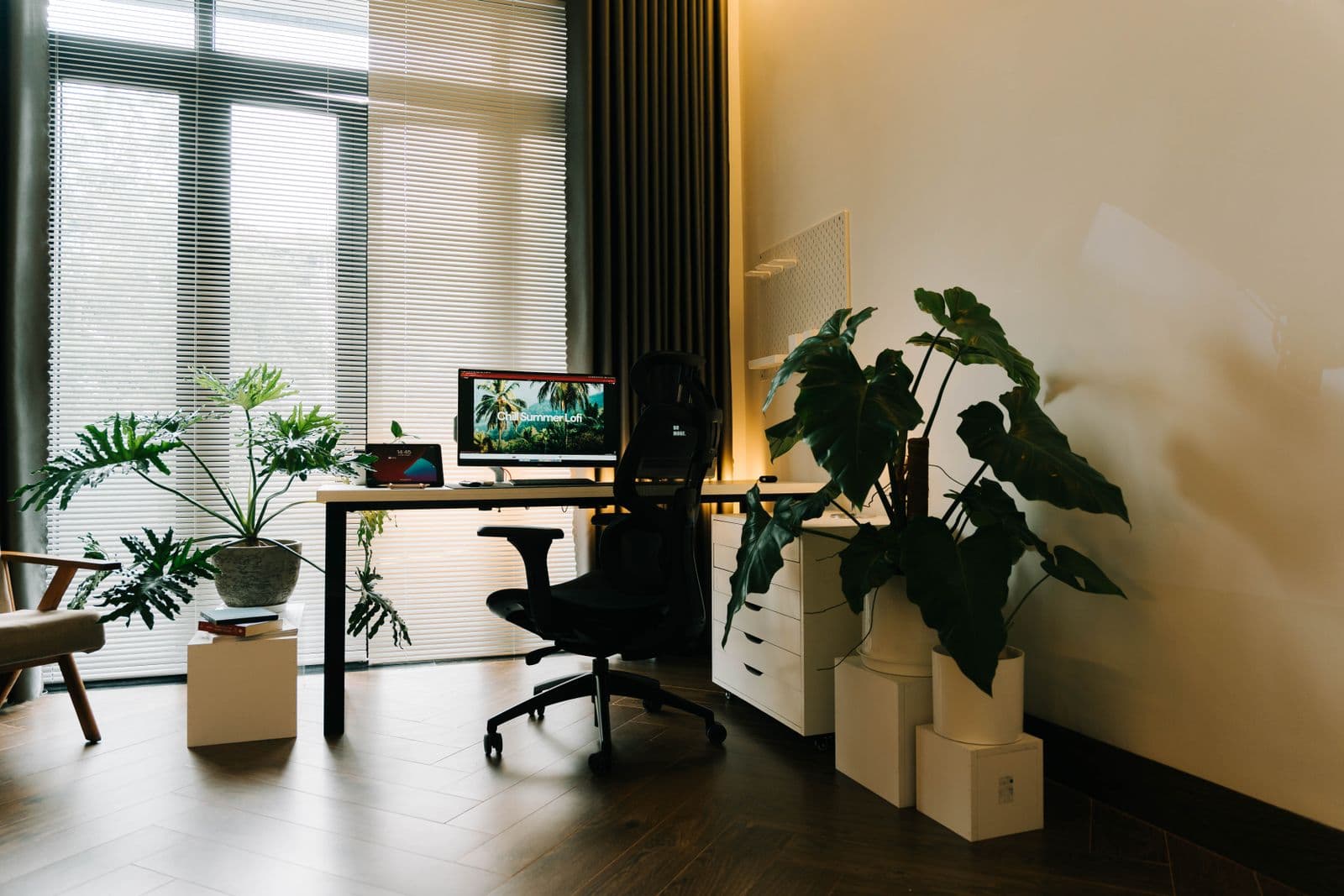 A person working at a height-adjustable oak desk in a bright home office